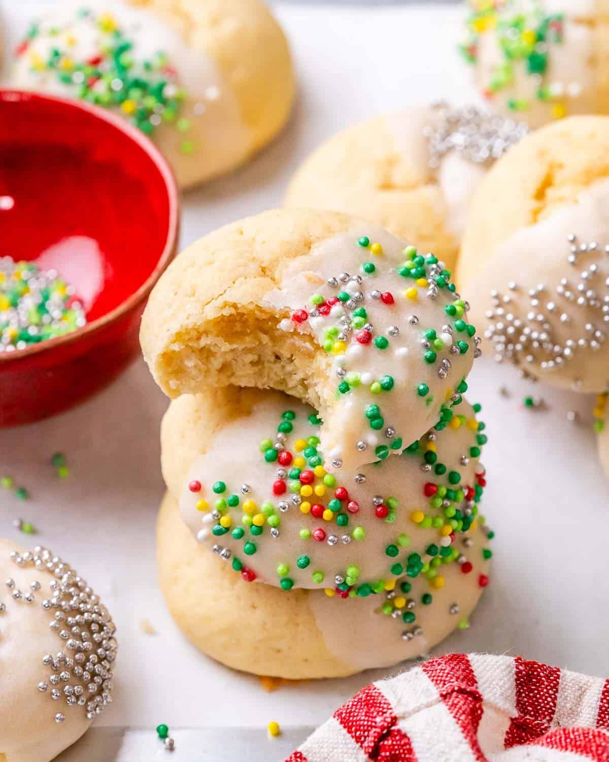 A stack of Italian Christmas Cookies, one with a bite taken out.