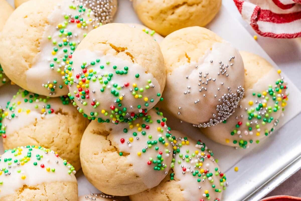 Italian Christmas Cookies with sprinkles next to a red and white striped napkin.