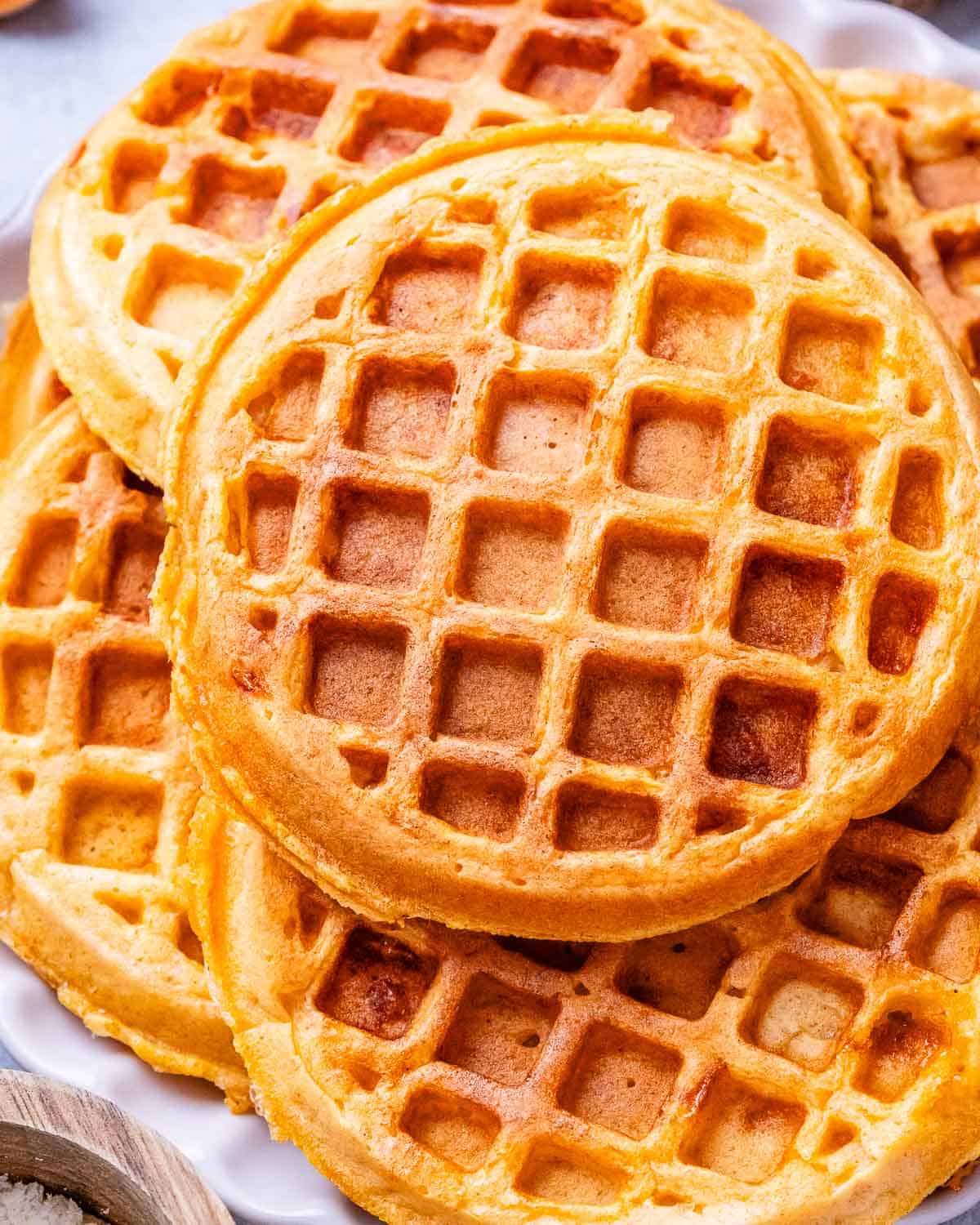 A stack of savory sweet potato waffles on a white plate.