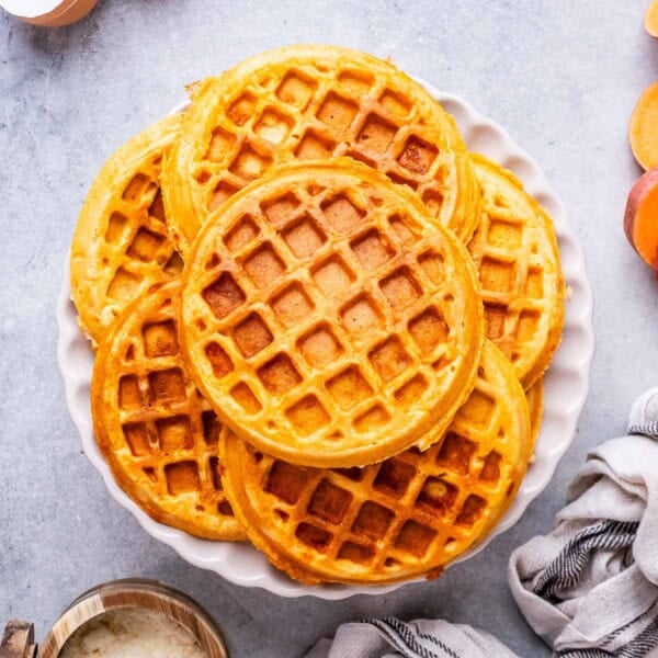 sweet potato waffles stacked on a plate.