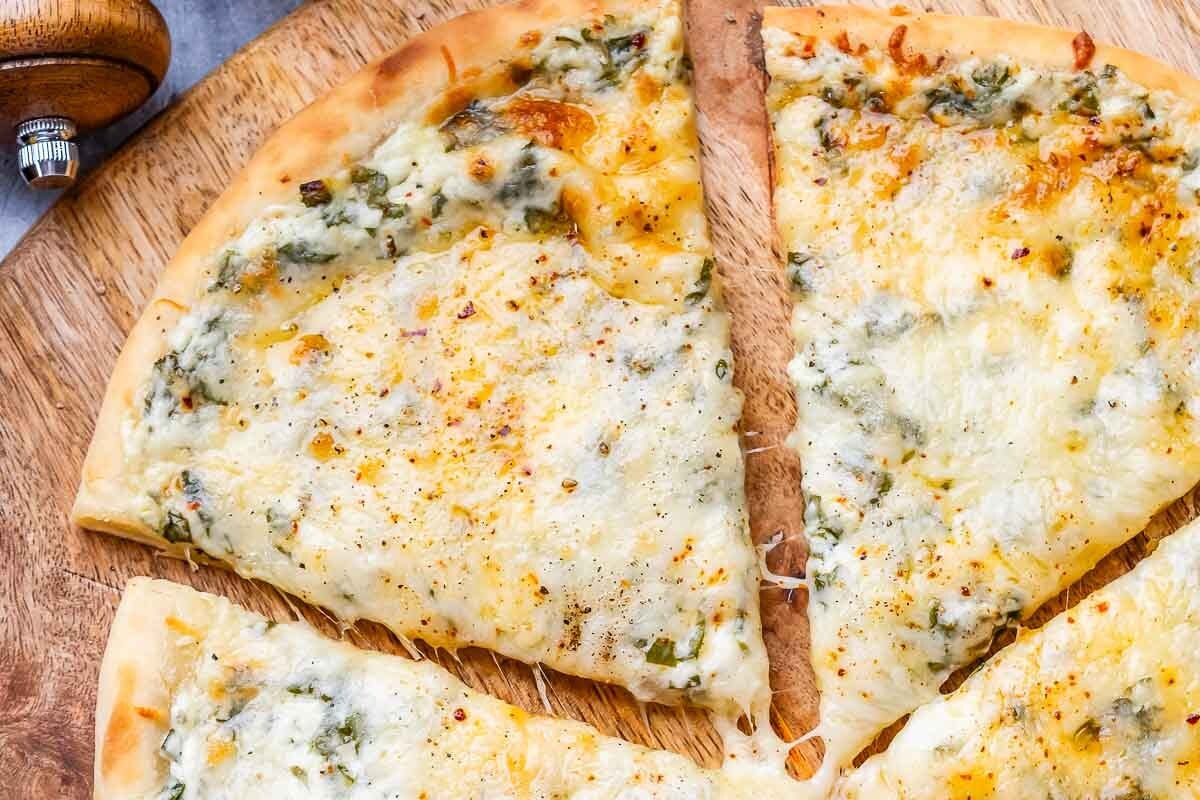 sliced white pizza on a cutting board.