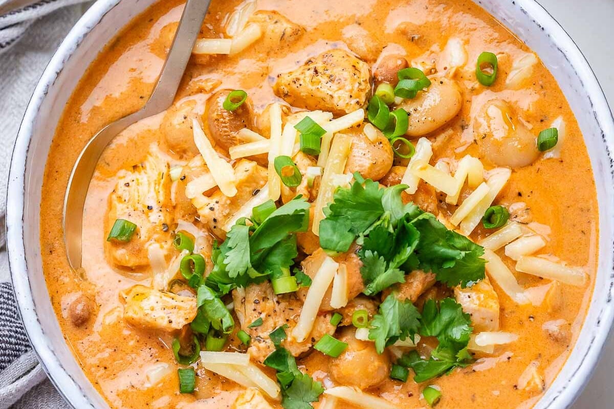 A white bowl of creamy crack chicken chili on a marble board.