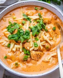 A white bowl of creamy crack chicken chili on a marble board.