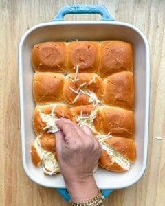 Stuffing the rolls with shredded cheese.