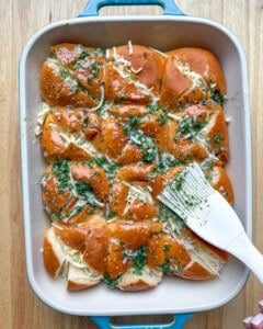 brushing the garlic butter mixture over the stuffed rolls.