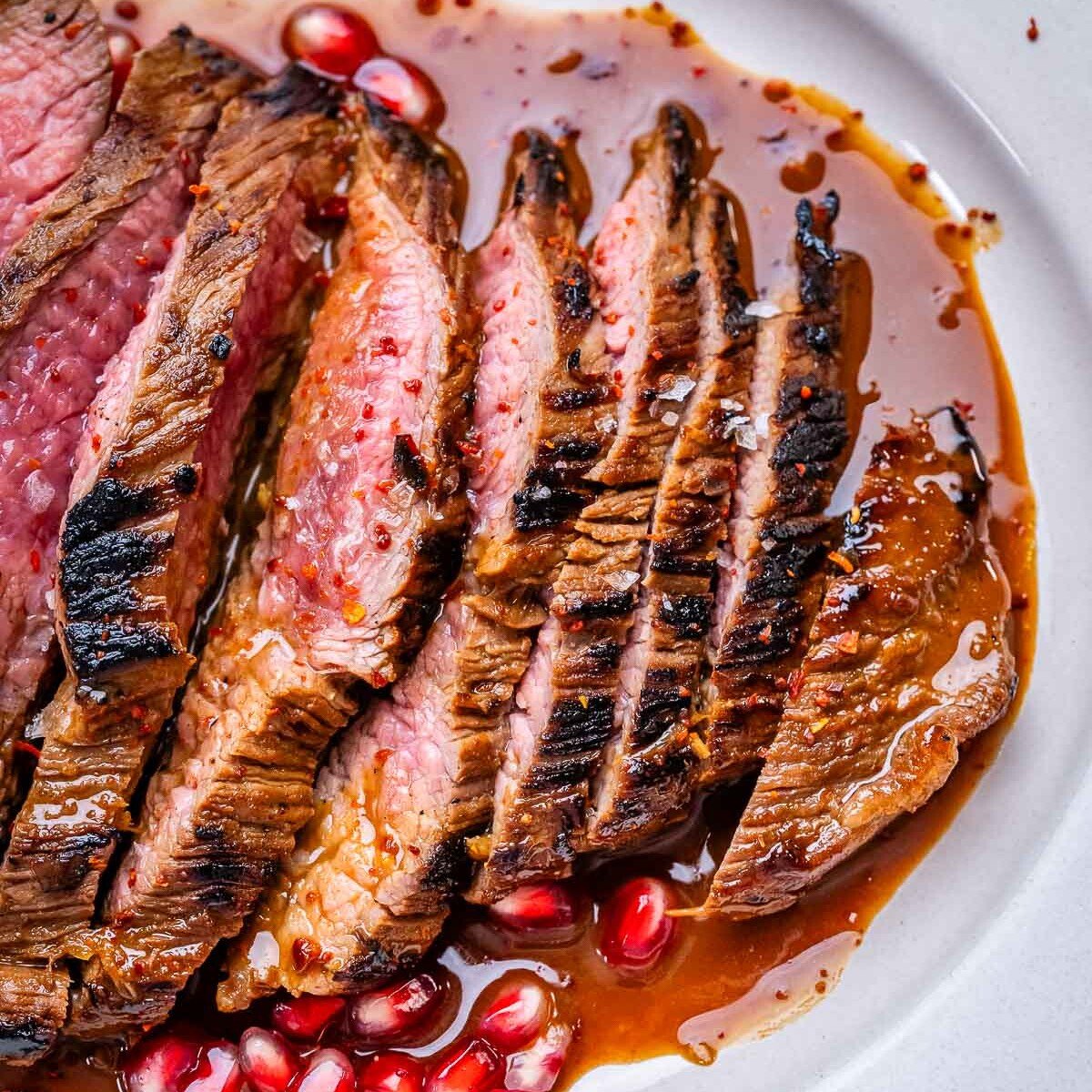 sliced marinated steaks on a plate.