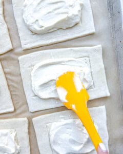 adding cream cheese filling to the pastry dough.