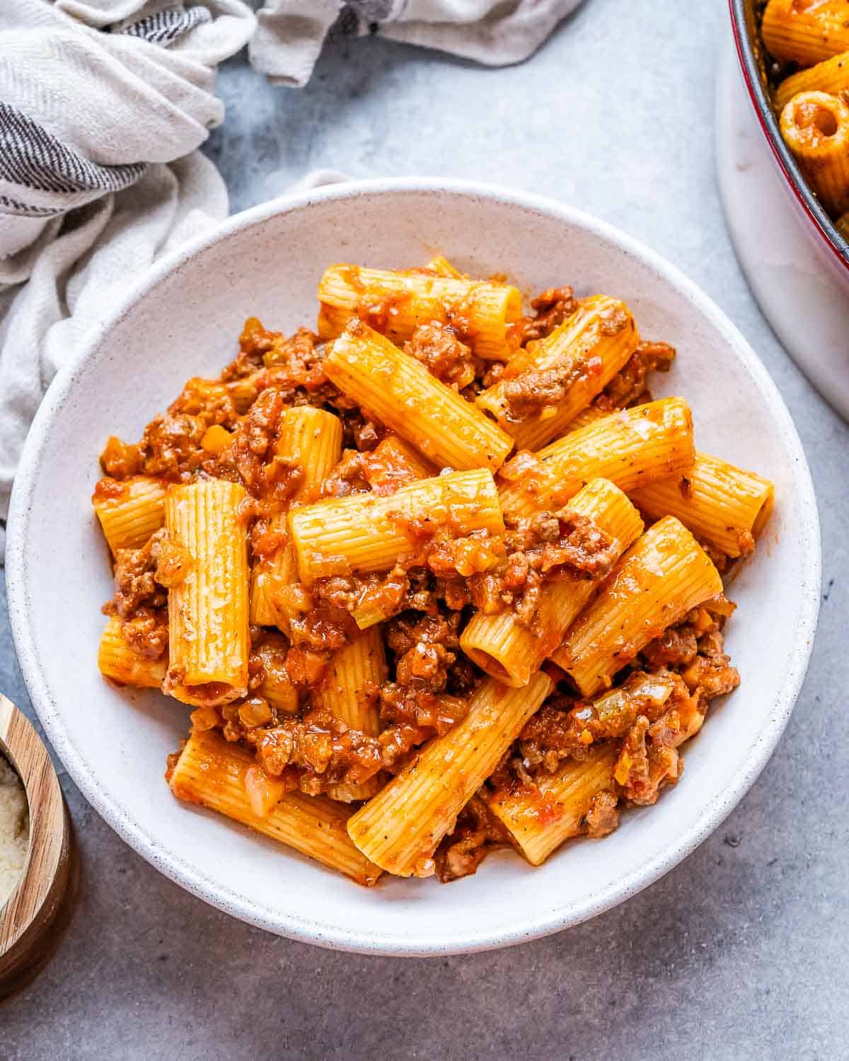 A white bowl with rigatoni bolognese.
