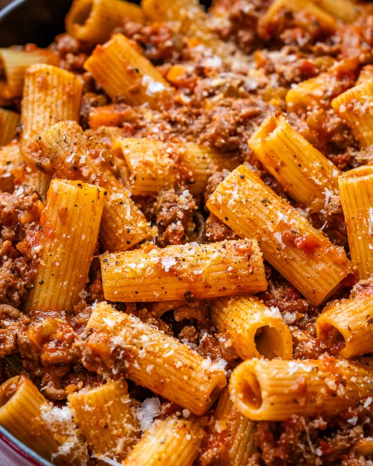 A close-up of rigatoni bolognese in a skillet.