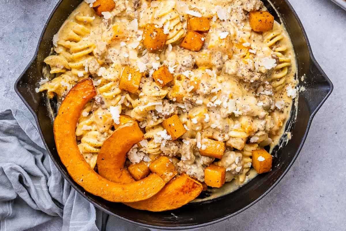a skillet with pasta, butternut squash, and creamy ground beef.