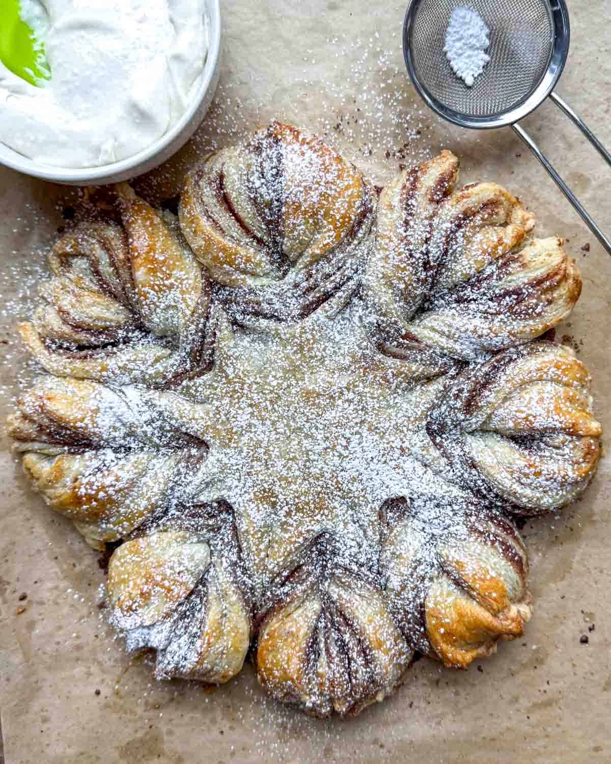 a puff pastry filled with cinnamon sugar, baked and topped with powdered sugar.