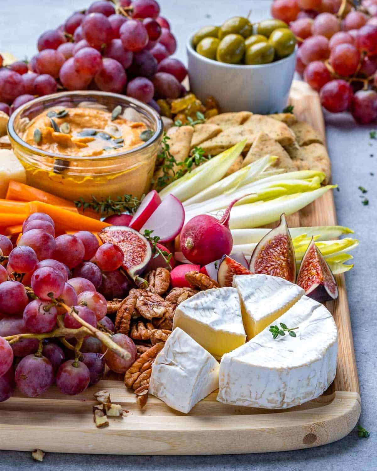a platter with cheese, fruits, nuts, and veggies, for the holidays.
