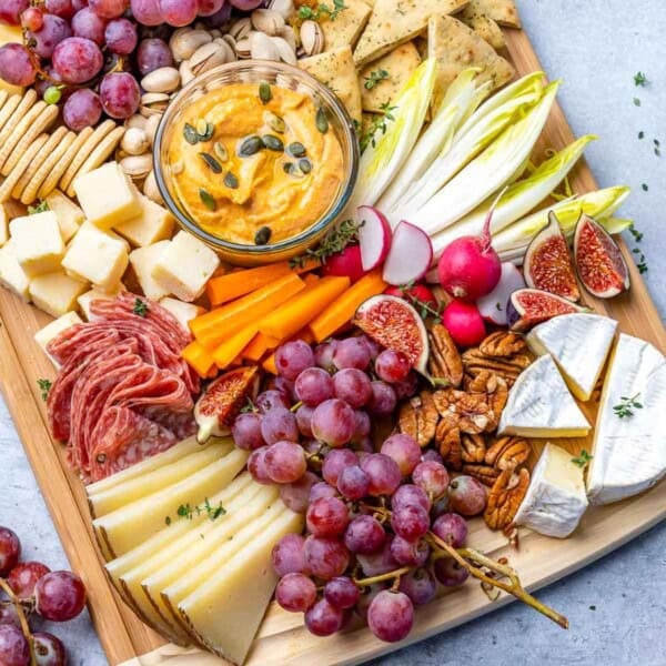 fruit and cheese set up on a cutting board.