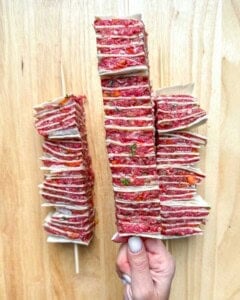 hand holding a single tortilla kebab.