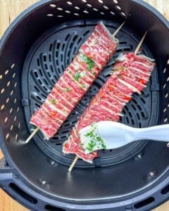 Basting the tortilla kebab in the air fryer.