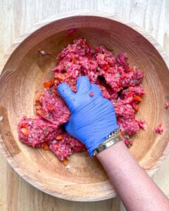 hand mixing the beef kebab mixture in a bowl.
