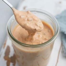 A spoon dipped in a cup full of Big Mac sauce.