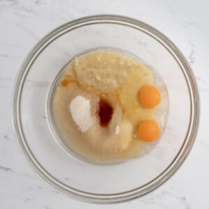 mashed banana, oil, sugar, vanilla, and eggs were added into a bowl.