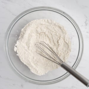 flour, baking powder, and baking soda added into a bowl.