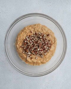 Chopped pecans added over muffin batter.