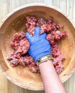 hand mixing the meat mixture together.