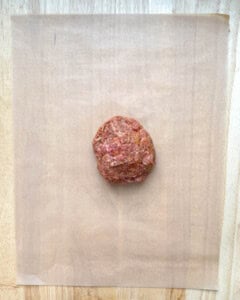 ball of meat over parchment paper.
