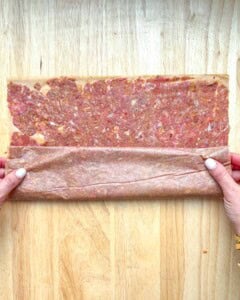 rolling the meat with the parchment paper.