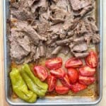 doner kebab beef on a sheet pan with tomatoes and peppers.