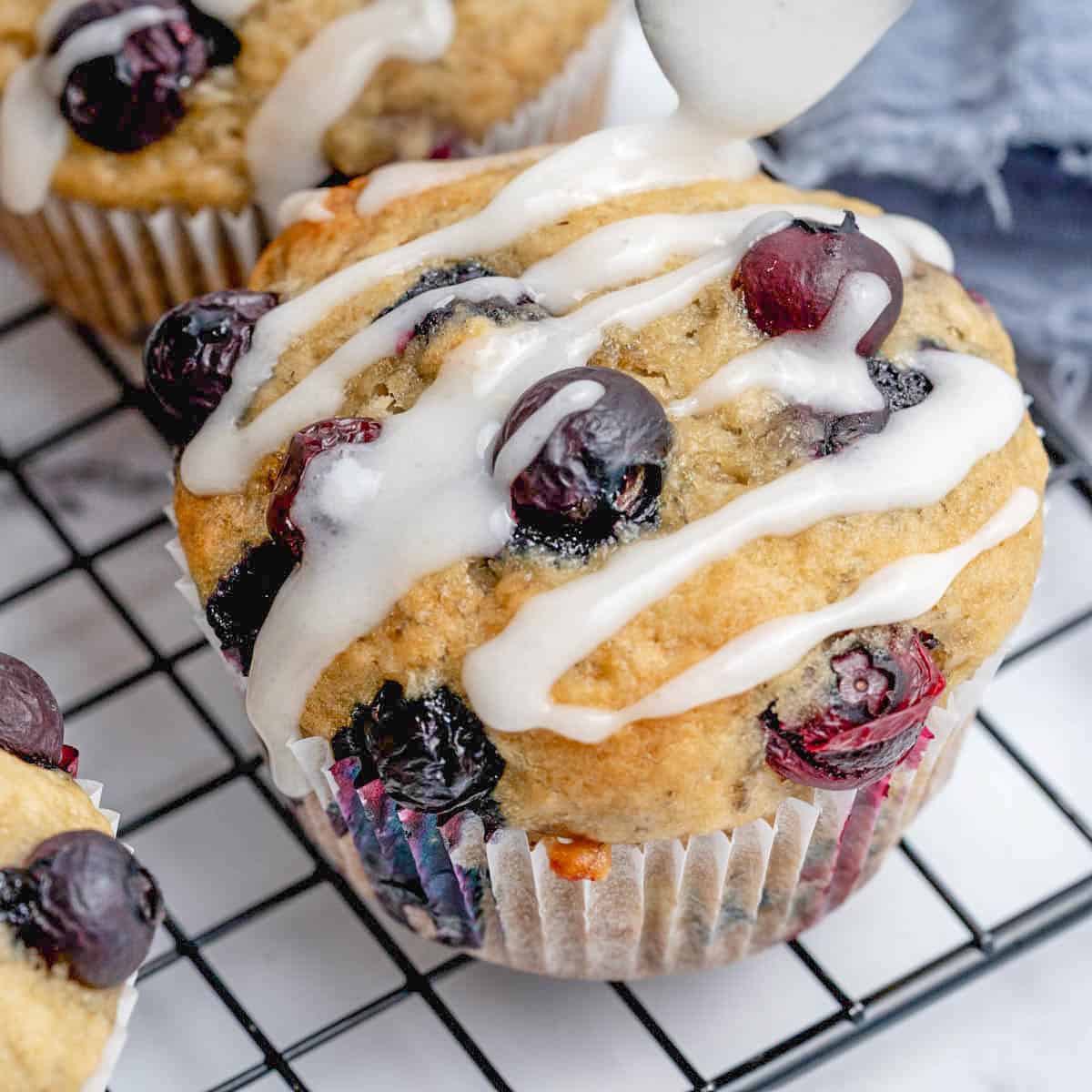 blueberry muffin on a wire rack with glaze over it.
