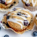 blueberry banana muffins on a muffin liner topped with icing sugar.