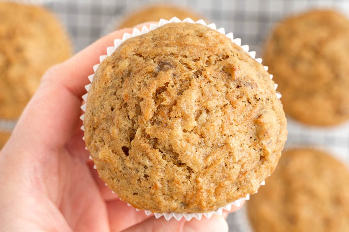 hand holding a carrot, a banana muffin.