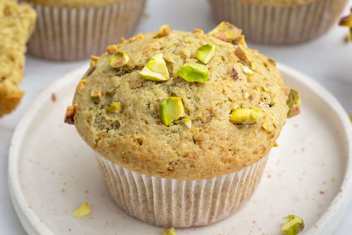 a pistachio muffin on a plate.