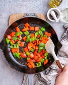 Cooking bell peppers in a skillet.