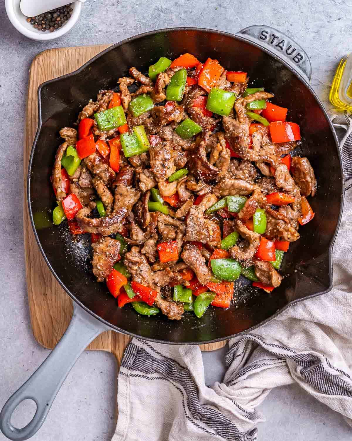 a skillet with pepper beef cooked with bell peppers.