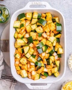 Seasoned zucchini and onions were added to a baking dish.