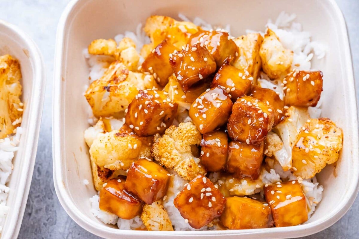 a bowl with sticky orange tofu over rice.