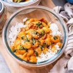 a meal prep glass bowl with marry me butter beans served over white rice.