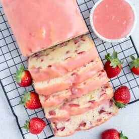 strawberry pound cake with half sliced through and topped with strawberry glaze.