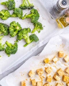 Broccoli and tofu are being prepared to be baked.