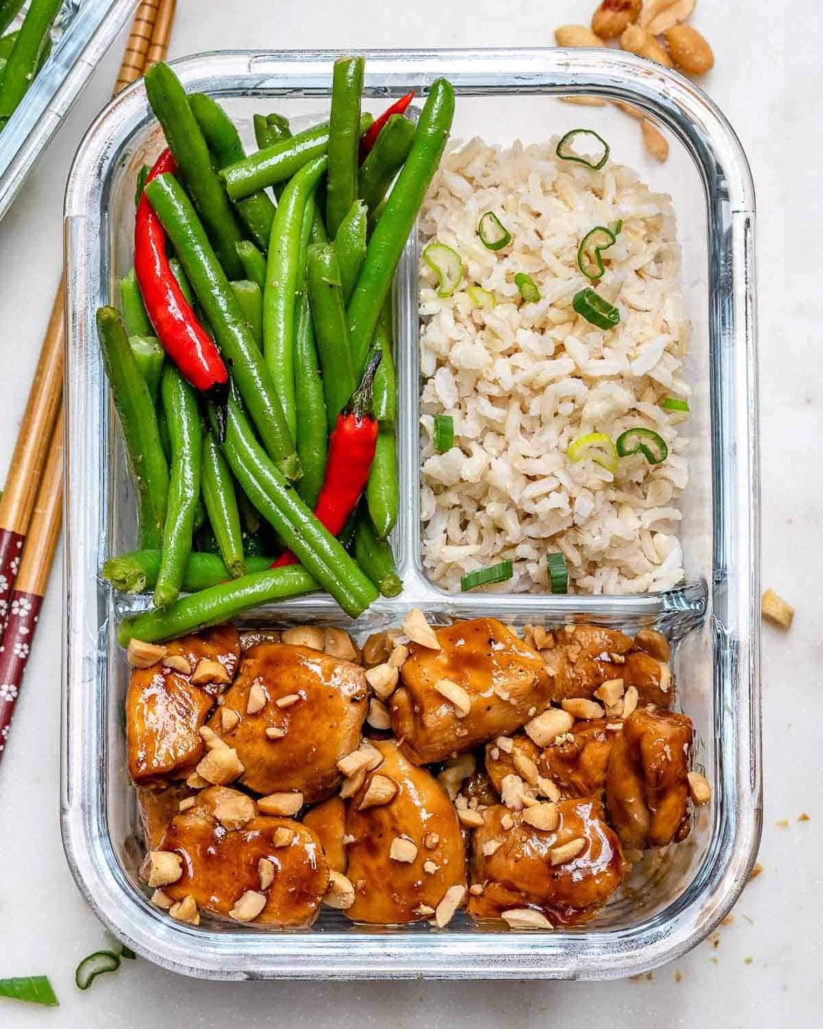 a glass meal prep bowl with chicken bites, brown rice, and green beans.