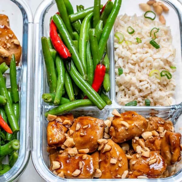 chicken bites meal prepped in a bowl with rice and a side of green beans.
