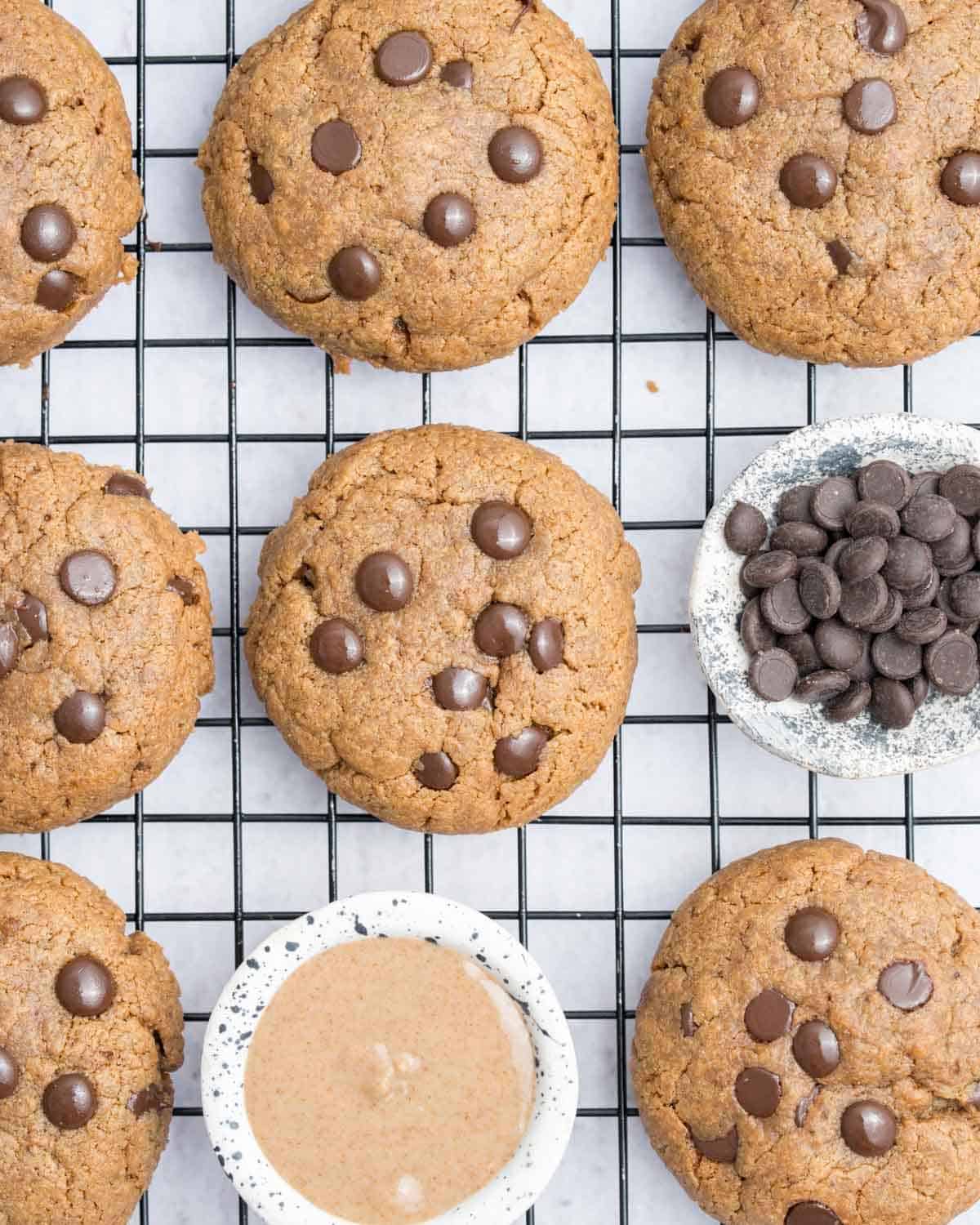 Almond butter cookies on a wire rack with chocolate chips and almond butter.