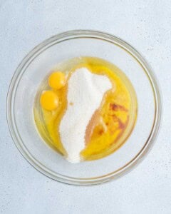 eggs, sugar, oil, and butter are added to a bowl to be mixed.