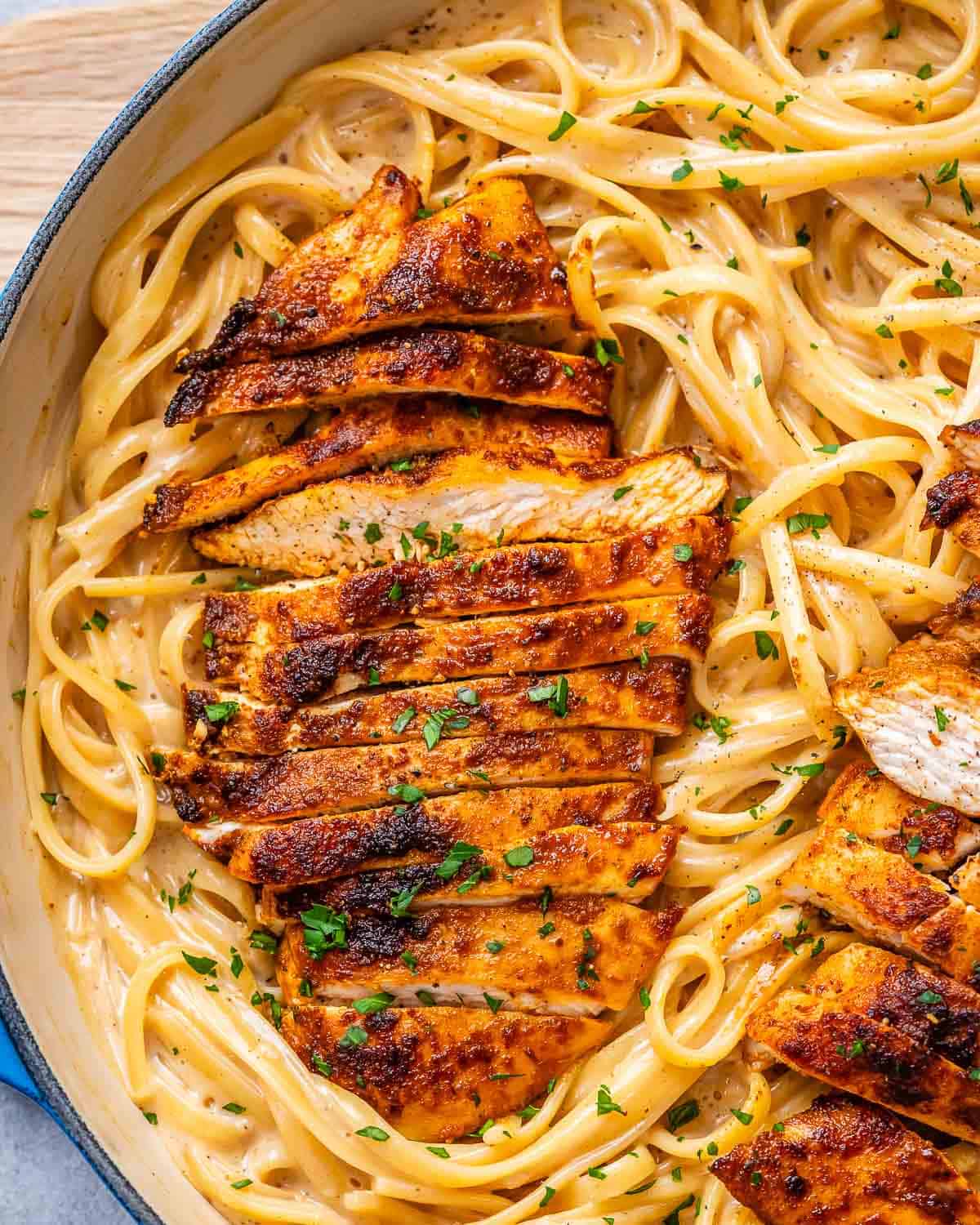pasta in creamy cajun sauce topped with sliced chicken.