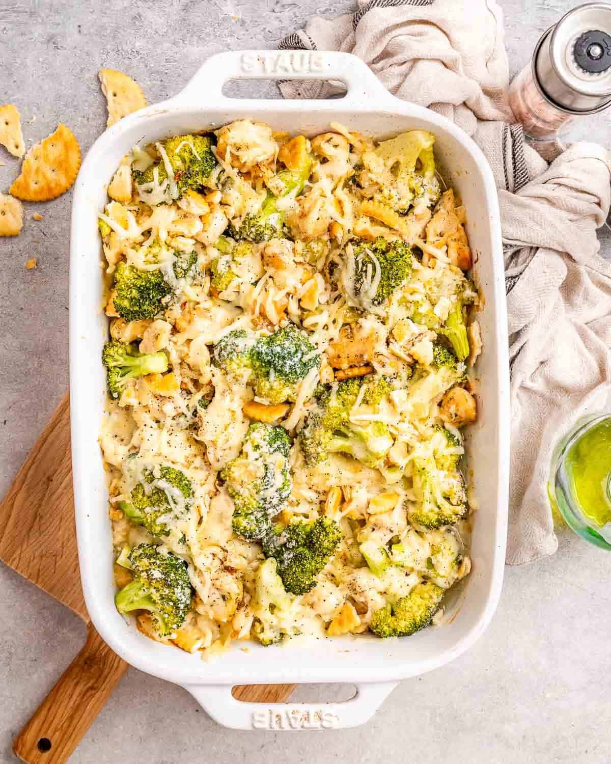 a casserole dish with chicken divan topped with shredded cheese and Ritz crackers.