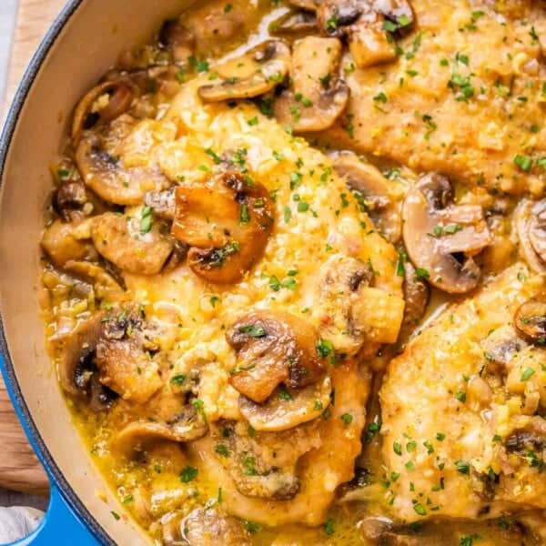 chicken and mushrooms in a skillet in a lemony sauce.
