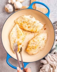 Cooking chicken breasts in a skillet.
