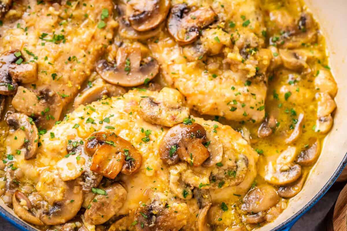 chicken scallopini in a skillet cooked in a lemon garlic sauce.