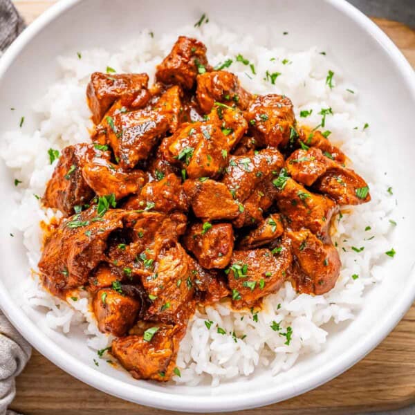 chicken vindaloo served over white rice in a bowl.