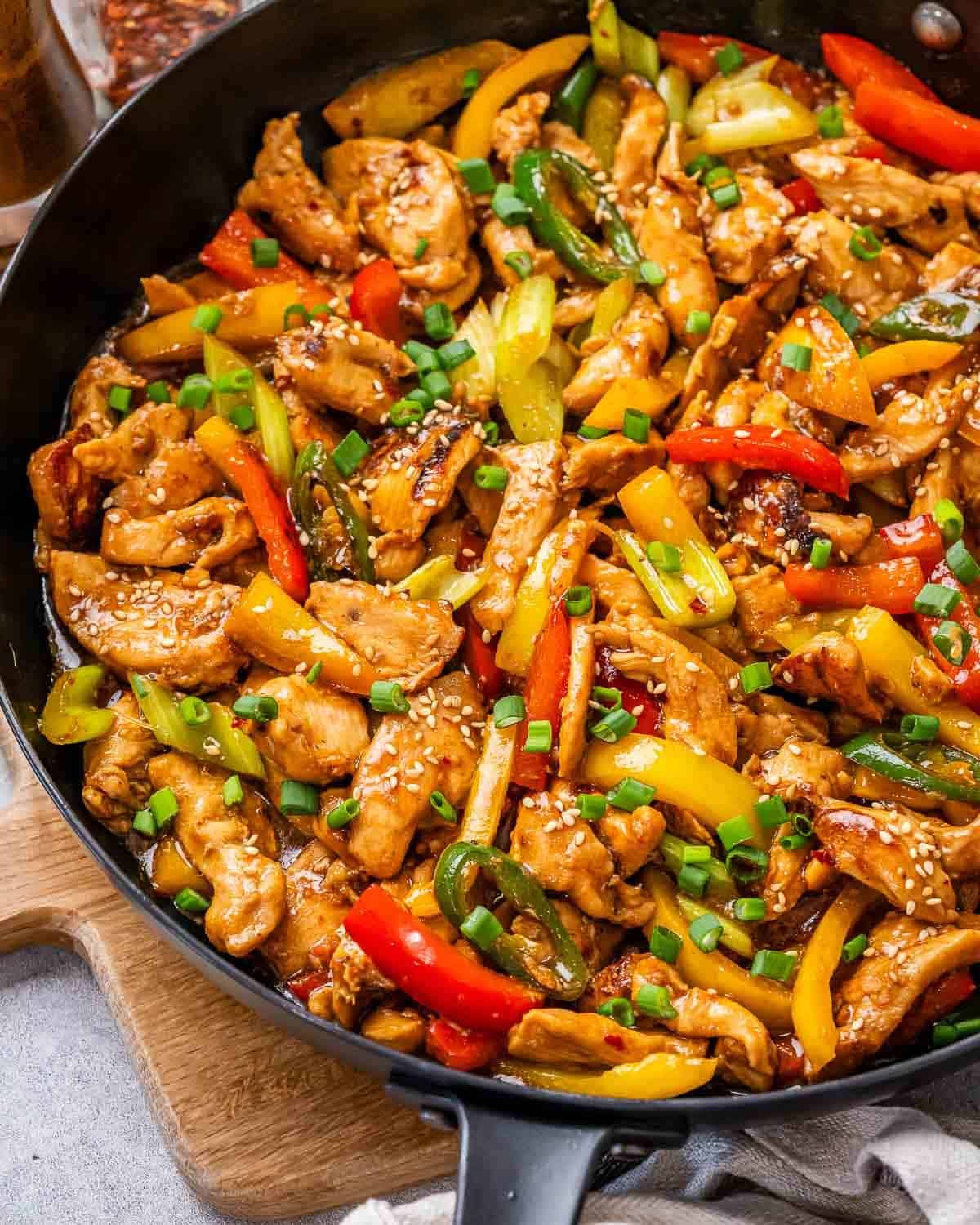 A wok with Hunan chicken, celery and bell peppers.